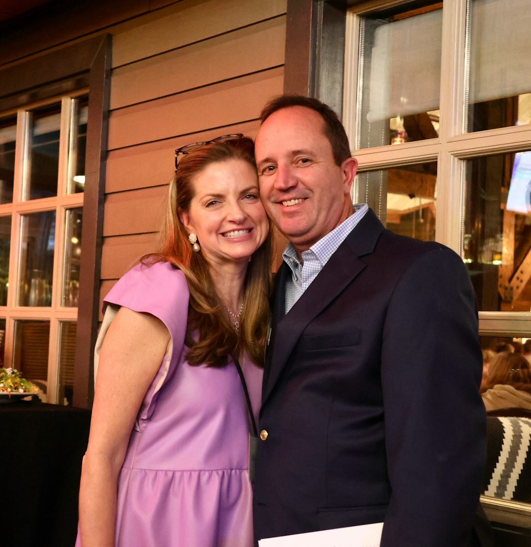 Well-dressed man and woman laughing together at an evening event
